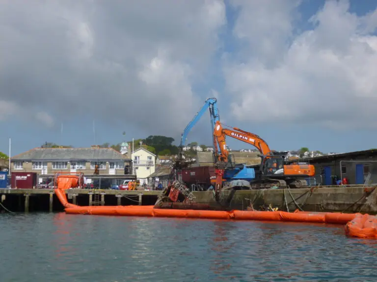 Gilpin marine division excavators working to dismantle a vessel in the harbour